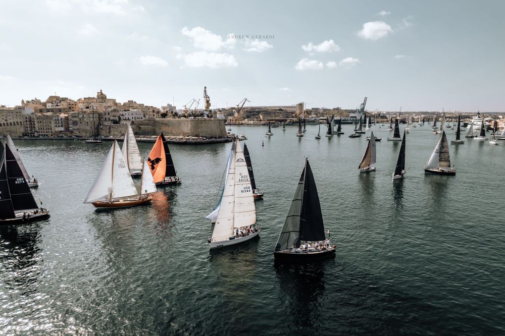 Panoramic view of sailboats scattered across a harbor during a regatta competition.
