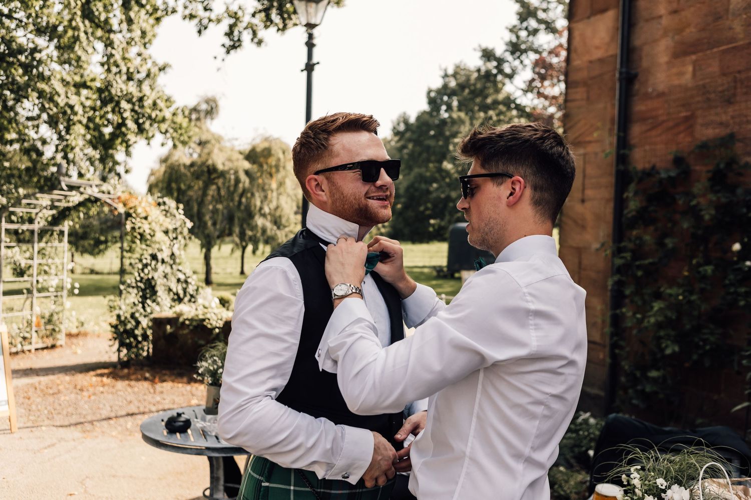groomsman adjusting bowtie on groom