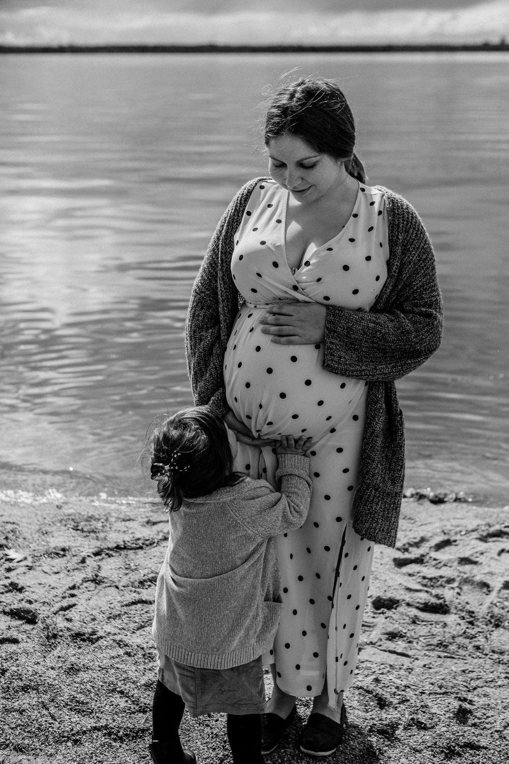 Black and white beachside maternity portraits showing tender moments.
