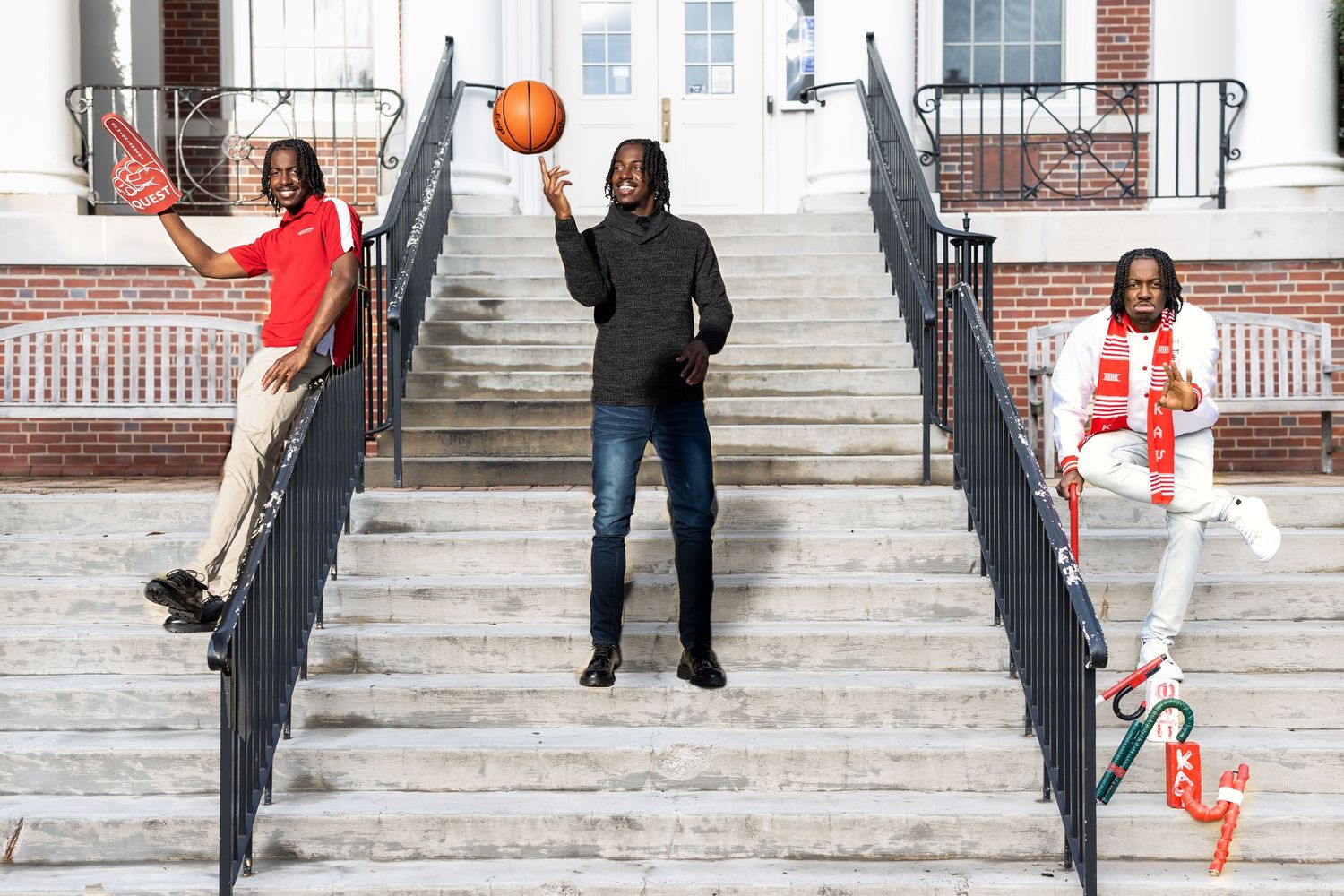 Three people strike dynamic poses on concrete steps while playing with a basketball.
