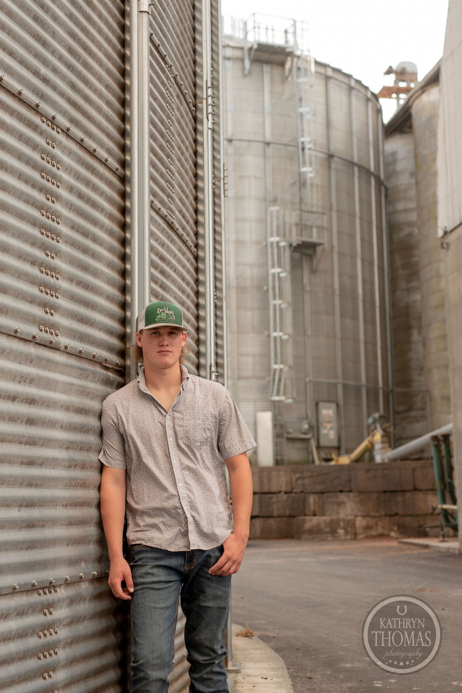 Industrial agricultural setting with metal storage silos and corrugated walls.