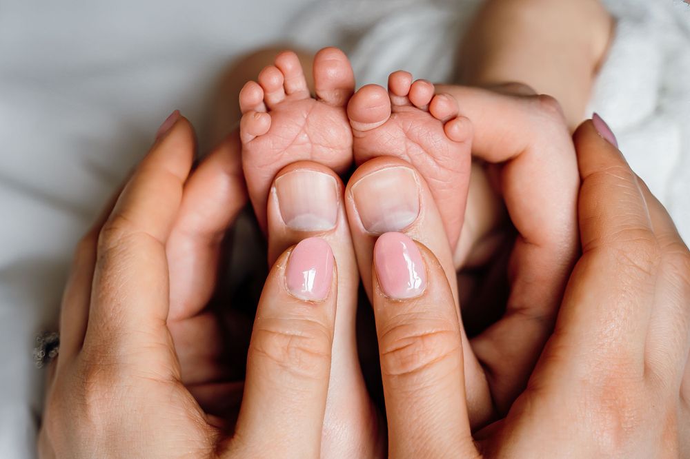 newborn photoshoot details baby toes infant and new parents in home session