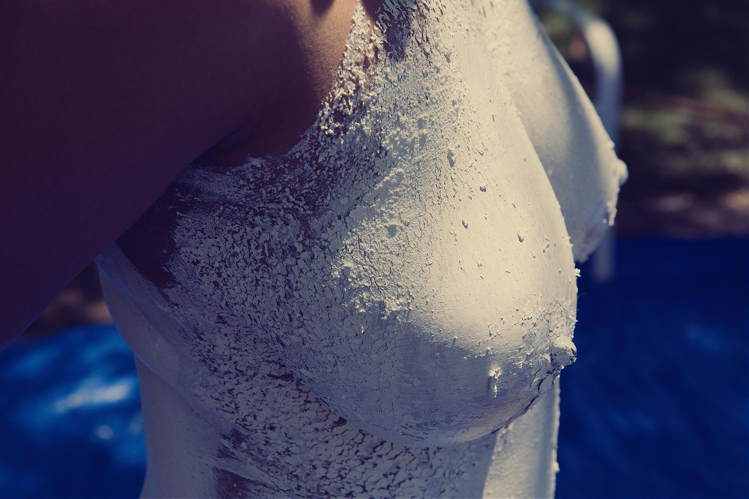 Artistic photo showing water droplets on skin with blue tonal background.
