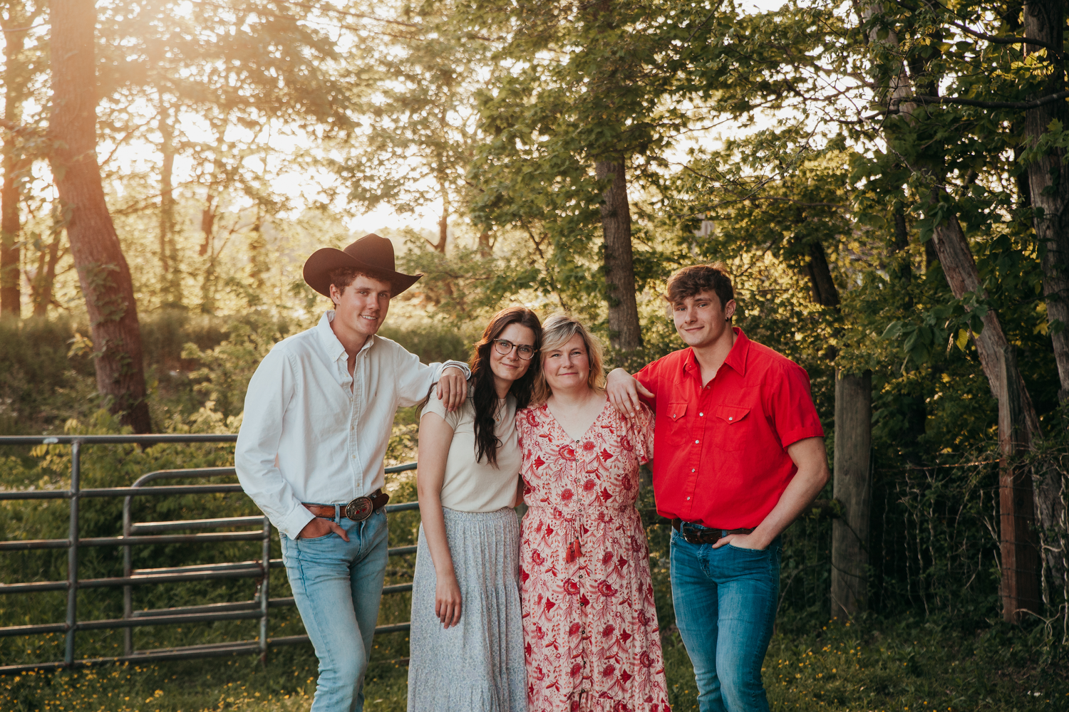 Family group poses together at sunset in wooded outdoor setting.