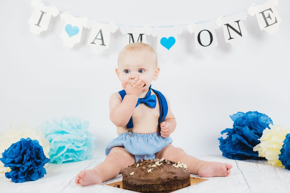 First birthday celebration setup with blue theme and chocolate cake smash props.