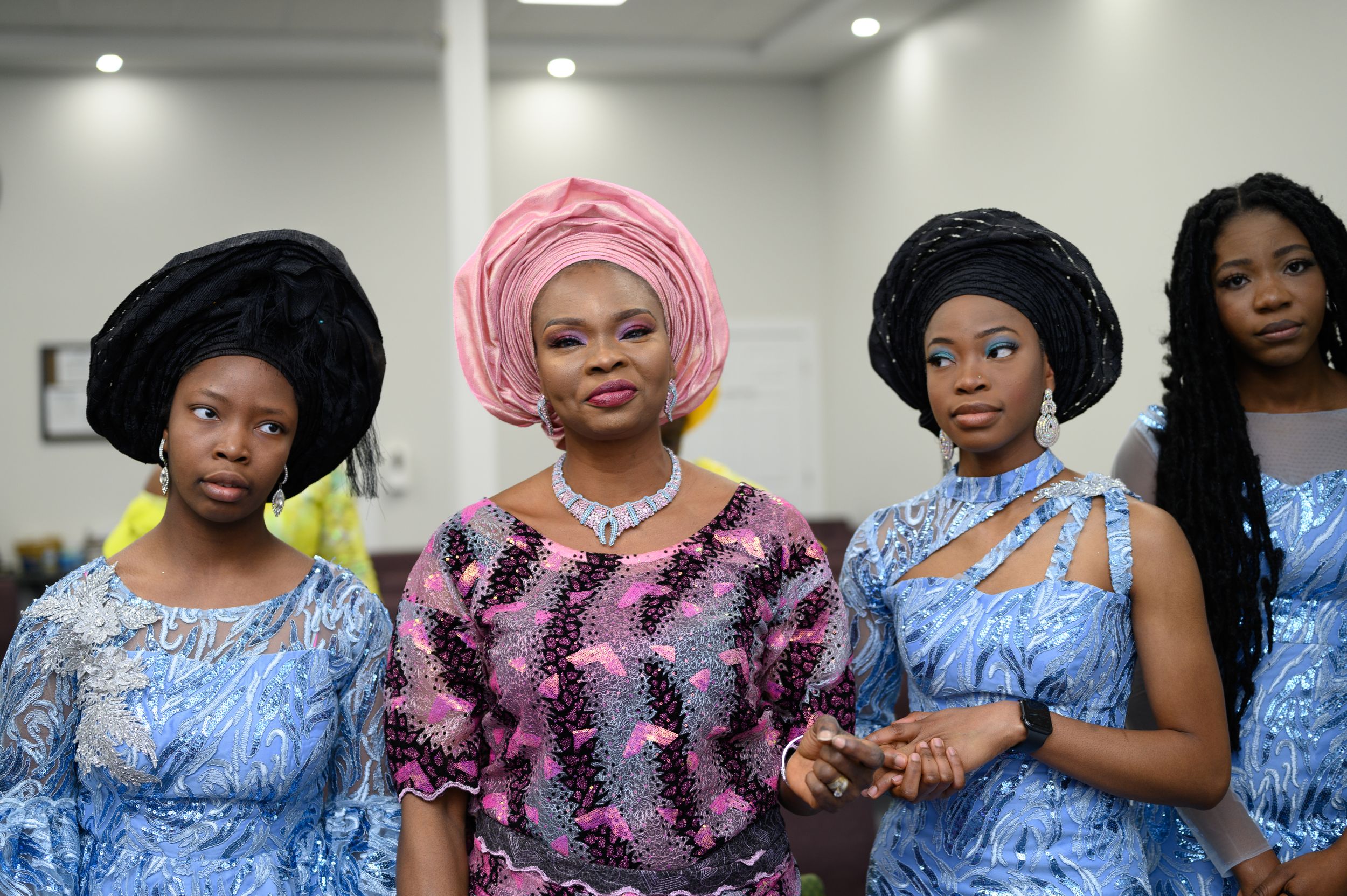 Group photo of women wearing coordinated traditional attire with geles and formal dresses.