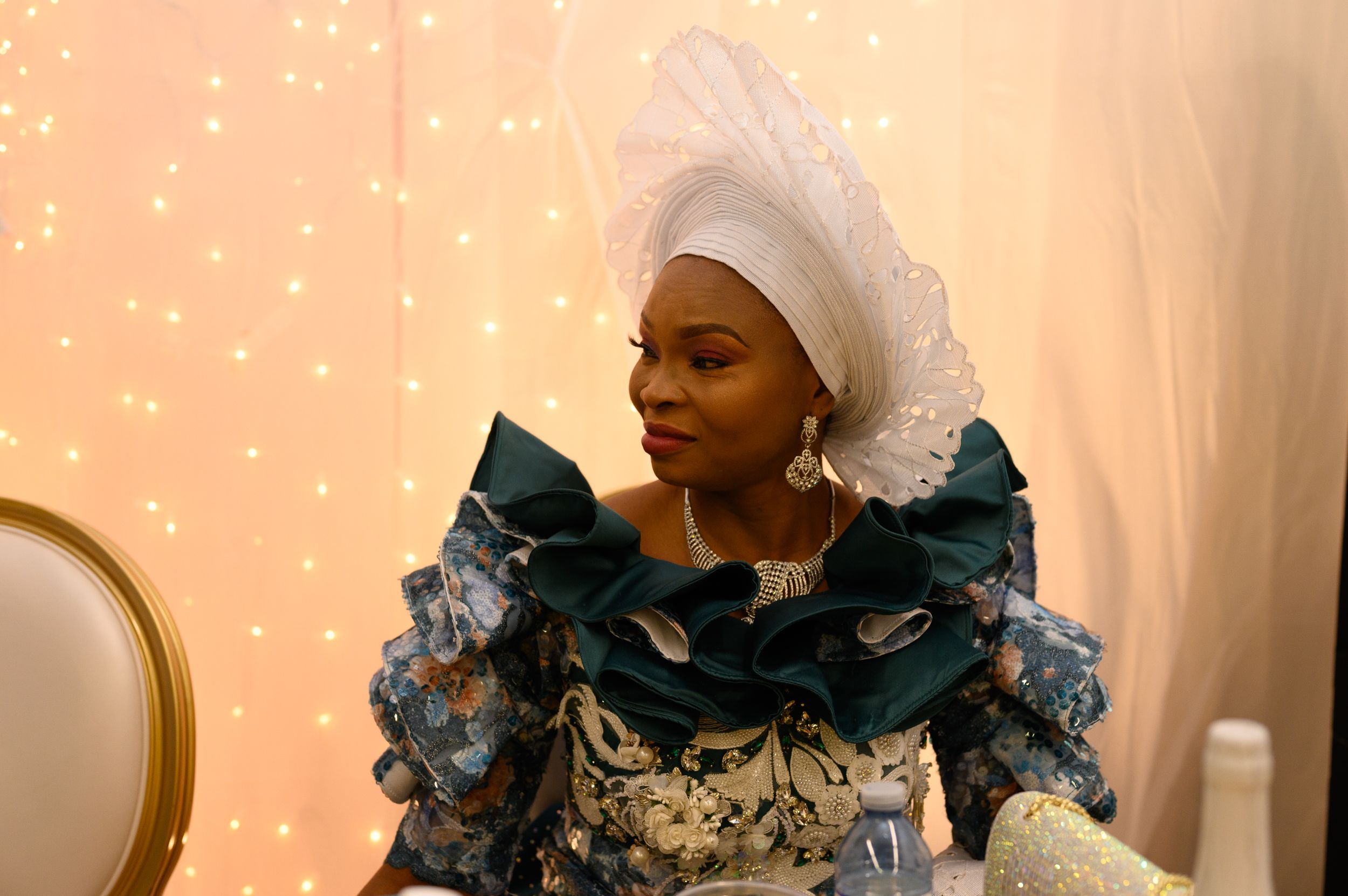 Person in elegant blue and white traditional dress with dramatic ruffled details.