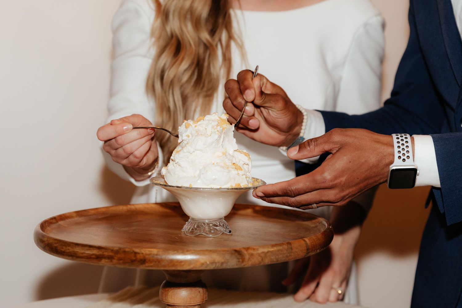 Close up of bride and groom hands eating ice cream together