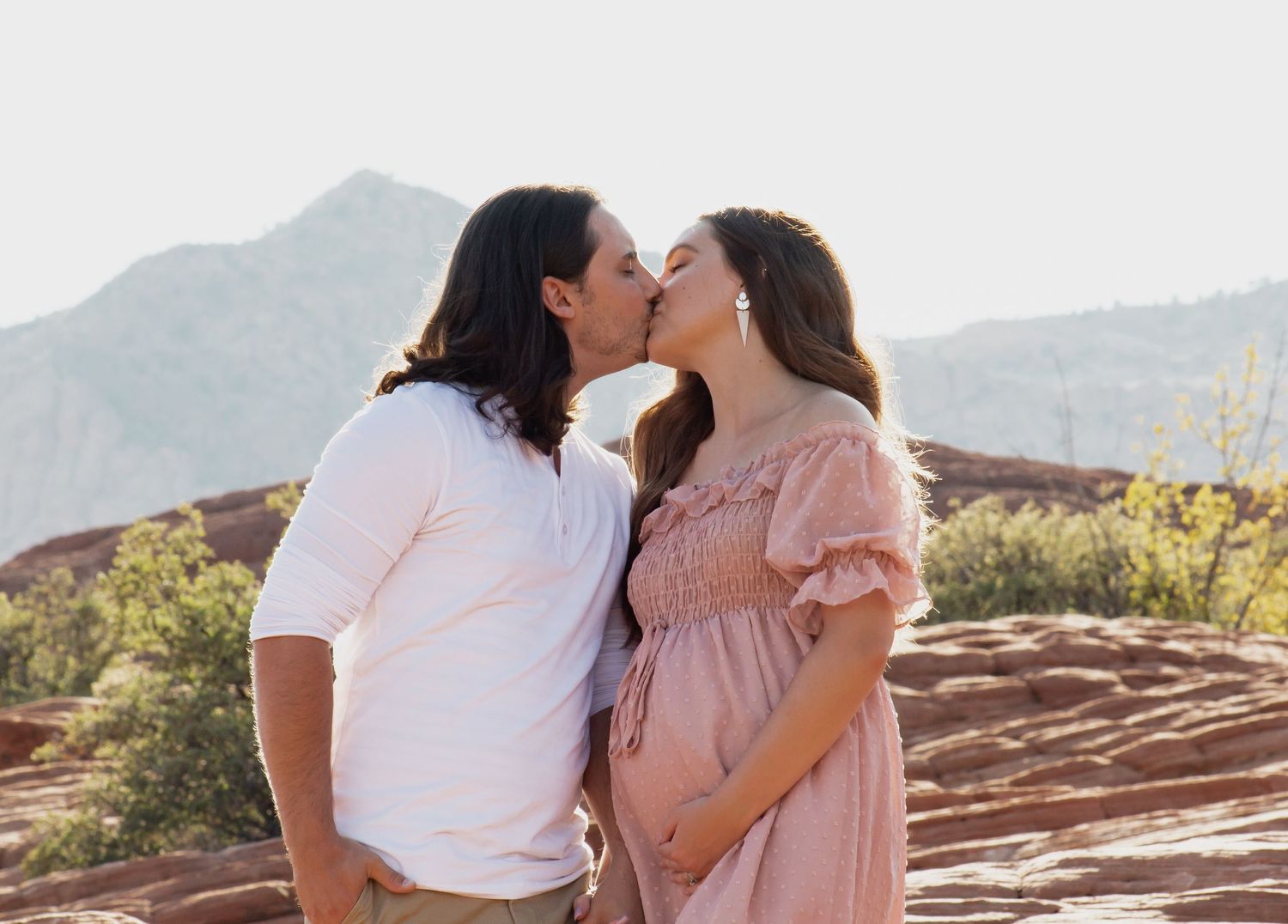 Couple kissing for maternity shoot