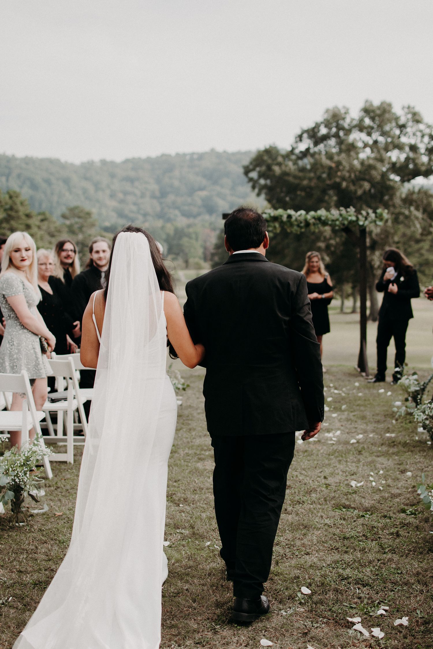 A couple walking down the aisle after their outdoor wedding ceremony.