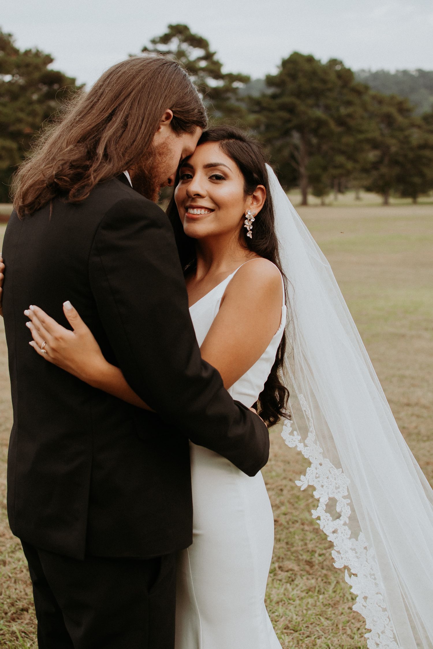 Intimate wedding portrait of couple embracing outdoors.