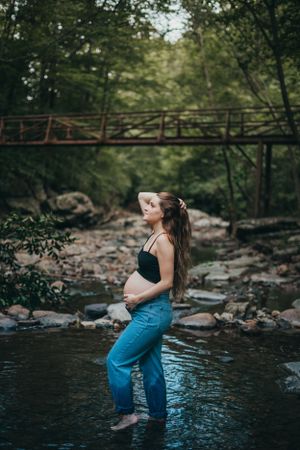 Intimate moment captured by a creek with rocks and trees creating a serene forest setting.