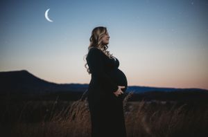 Crescent moon visible in dusky blue sky during outdoor portrait session.