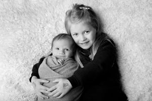 Black and white portrait of children on white furry backdrop.