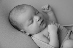Black and white portrait of sleeping newborn with peaceful expression.