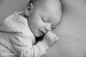 Side profile of sleeping baby in knitted sweater.