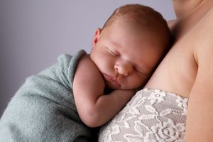 Nouveau-né paisiblement endormi contre sa maman.