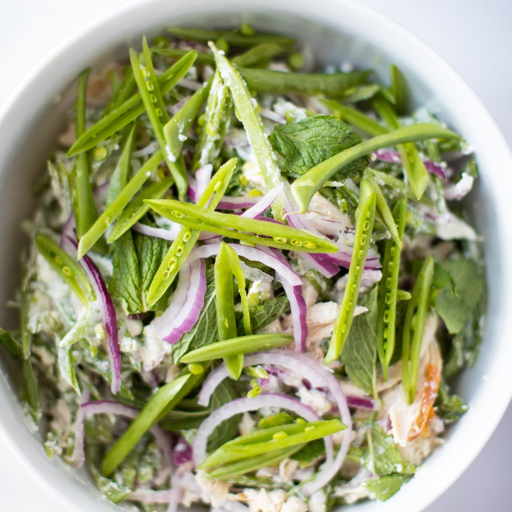 Fresh salad bowl with mixed greens, purple onions, and light dressing.