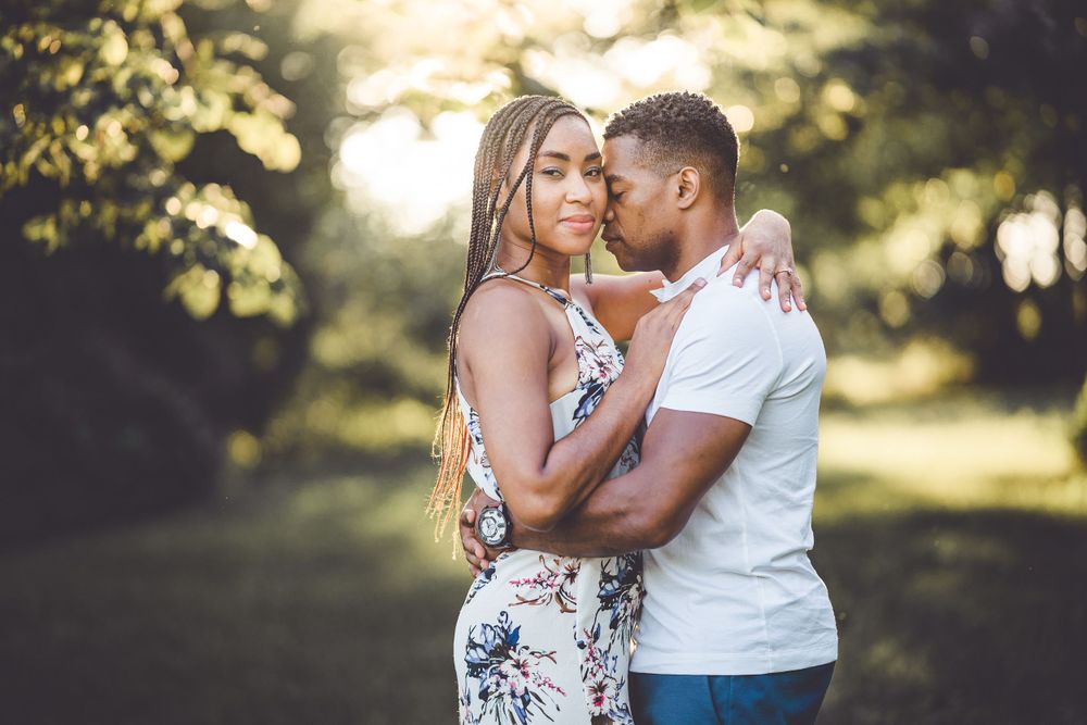 Romantic couple photoshoot in golden hour sunlight with natural outdoor backdrop.
