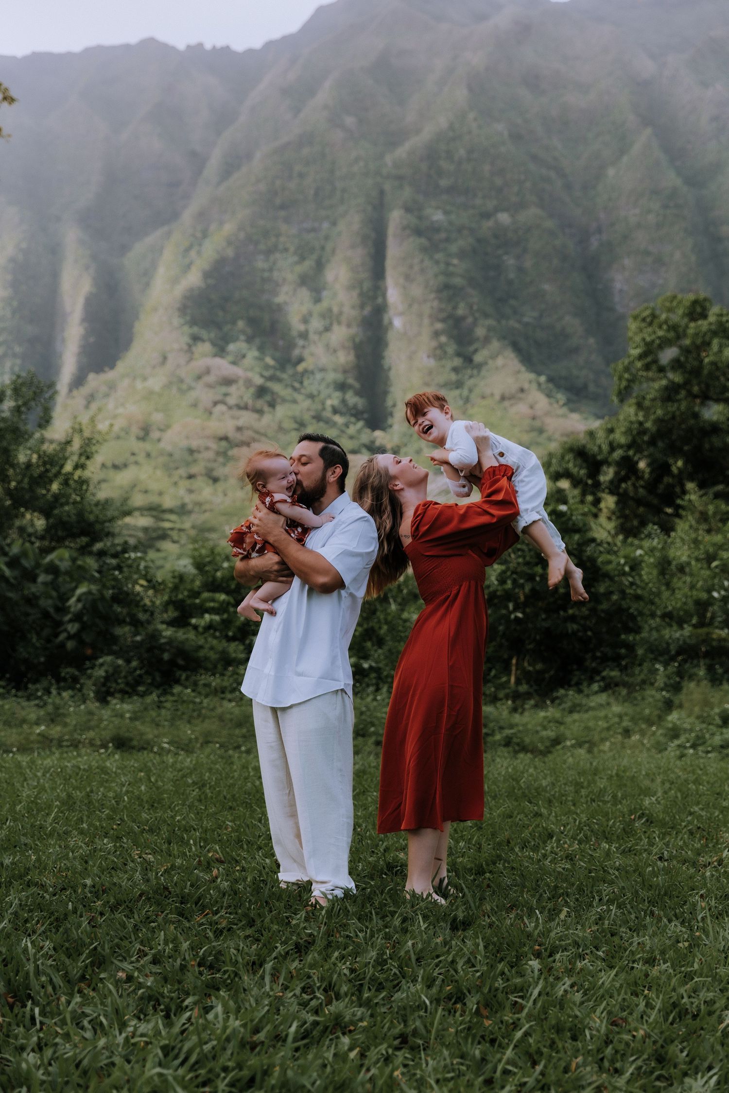 People in white and red outfits pose playfully against a backdrop of dramatic mountain peaks.