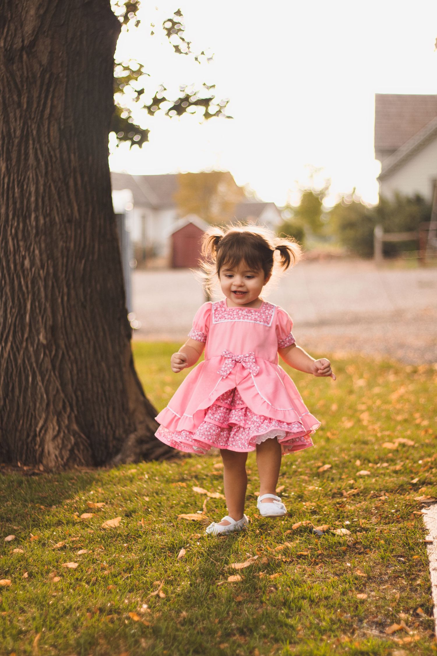 happy smiling toddler girl wearing pink dress running toward camera