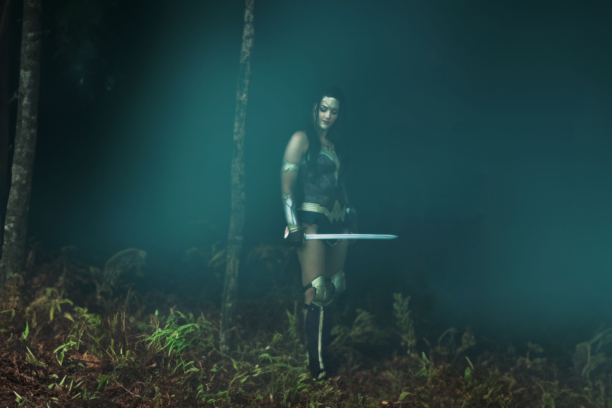Dramatic portrait of warrior figure in misty forest with sword at night.