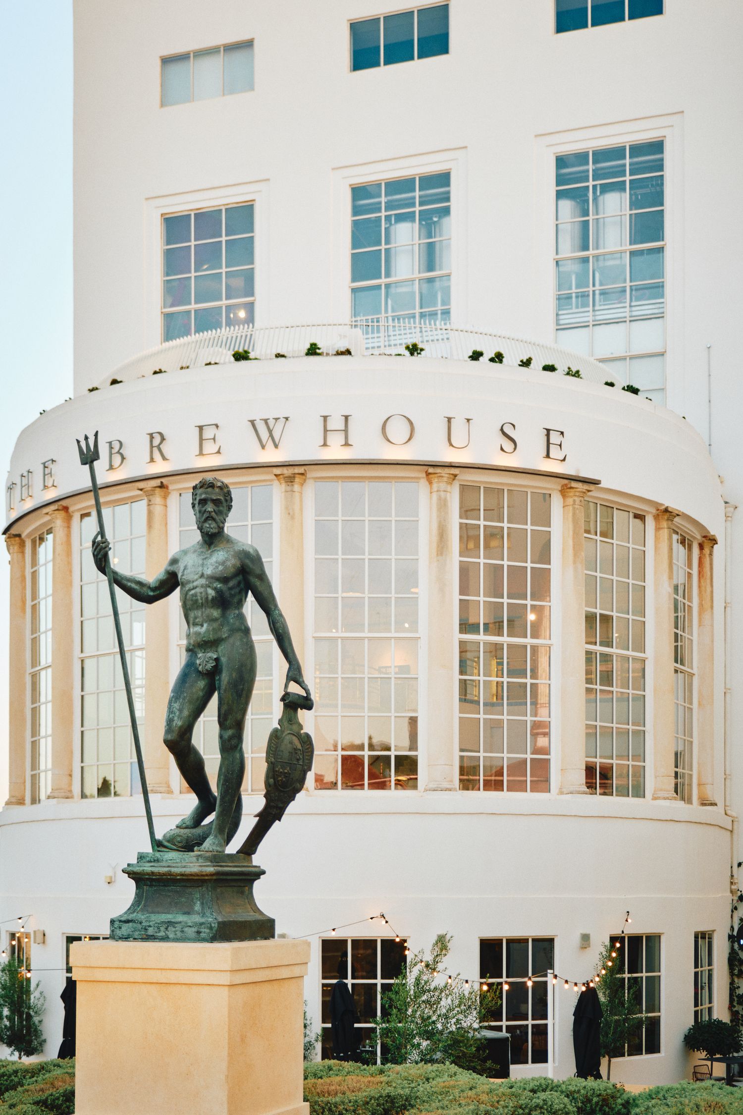 Art deco style brewhouse building exterior with classical statue decoration.