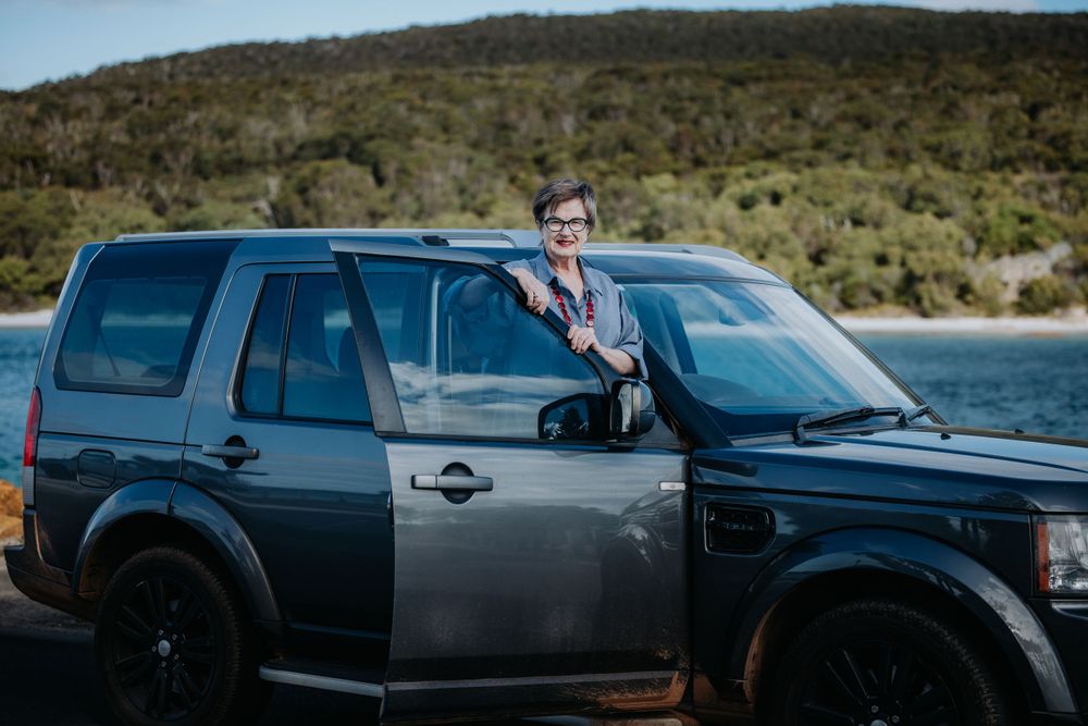 Black SUVs parked in a row against a scenic mountain landscape.