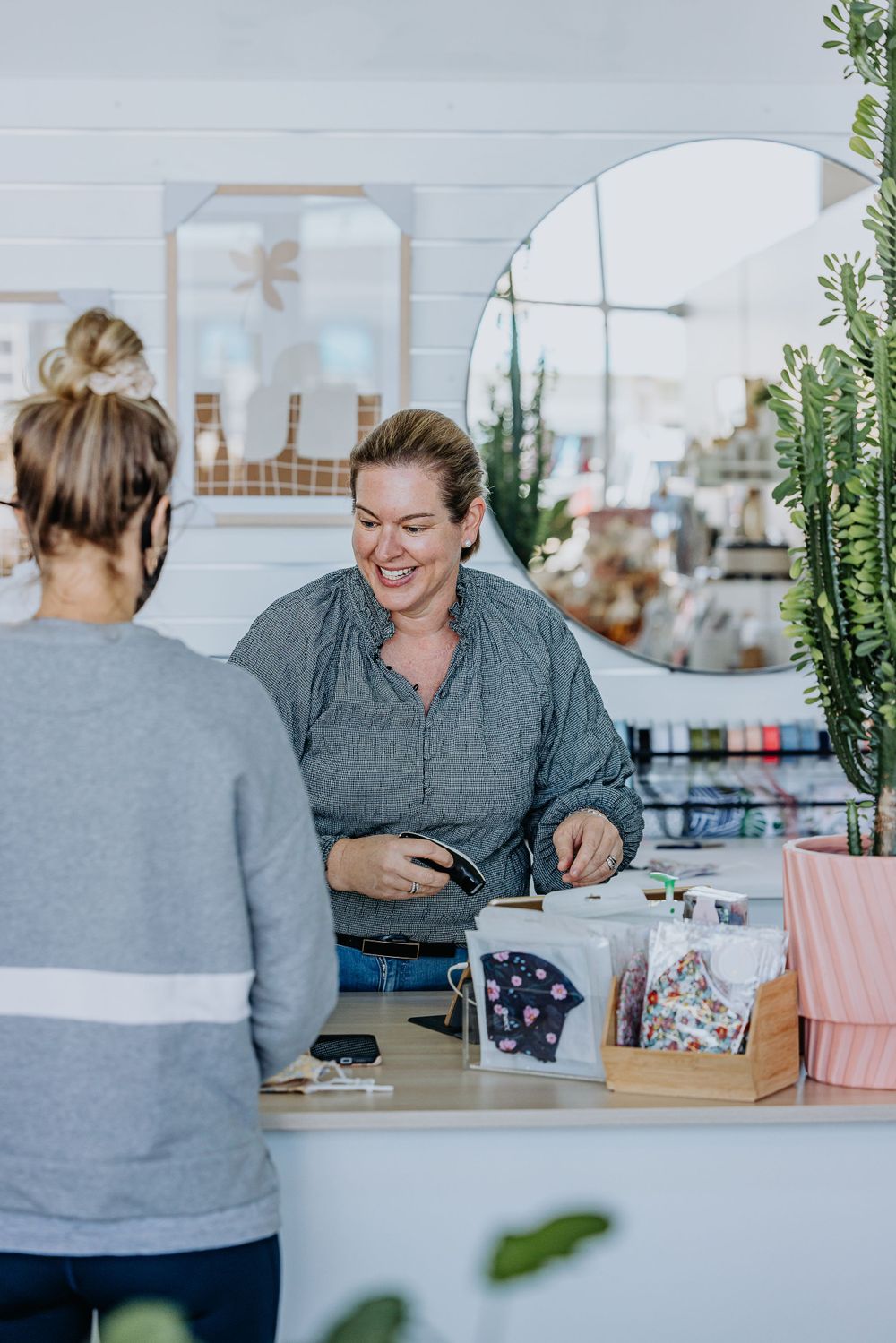 Two people having a business meeting at a bright modern office desk with plants.