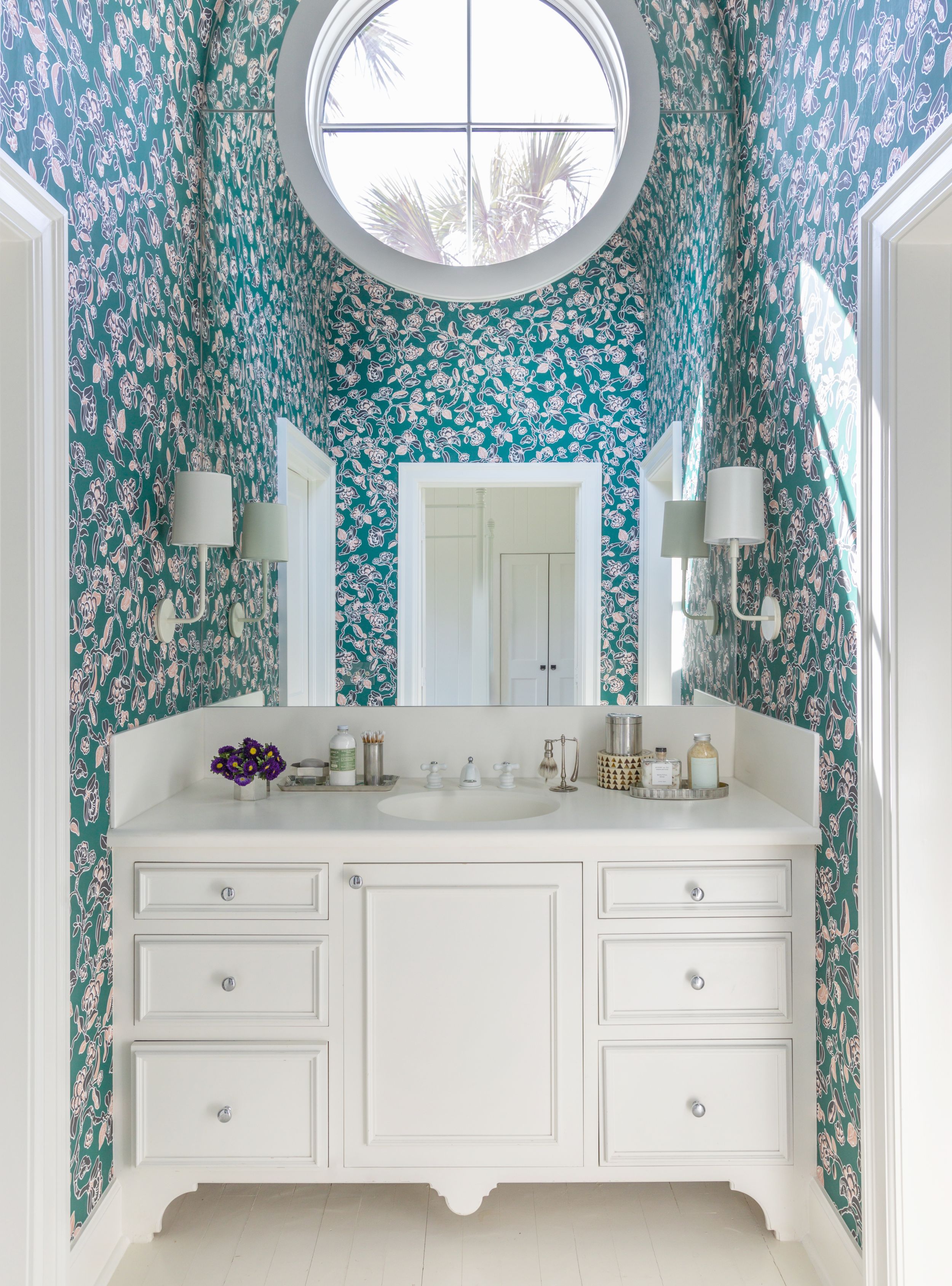 Green and pink Cannon & Bullock wall covering with white dresser and circular window