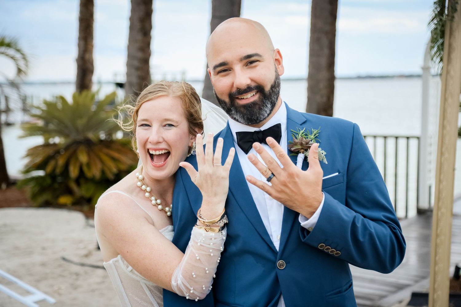 A joyful wedding celebration moment on a tropical waterfront.