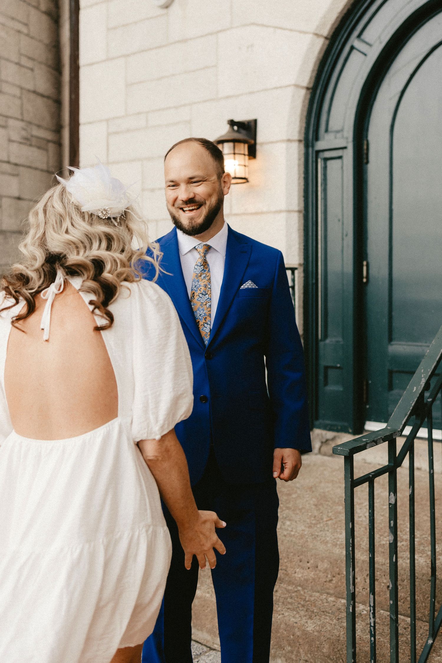 A romantic wedding moment between a couple where the bride wears a white dress and groom dons a navy blue suit.