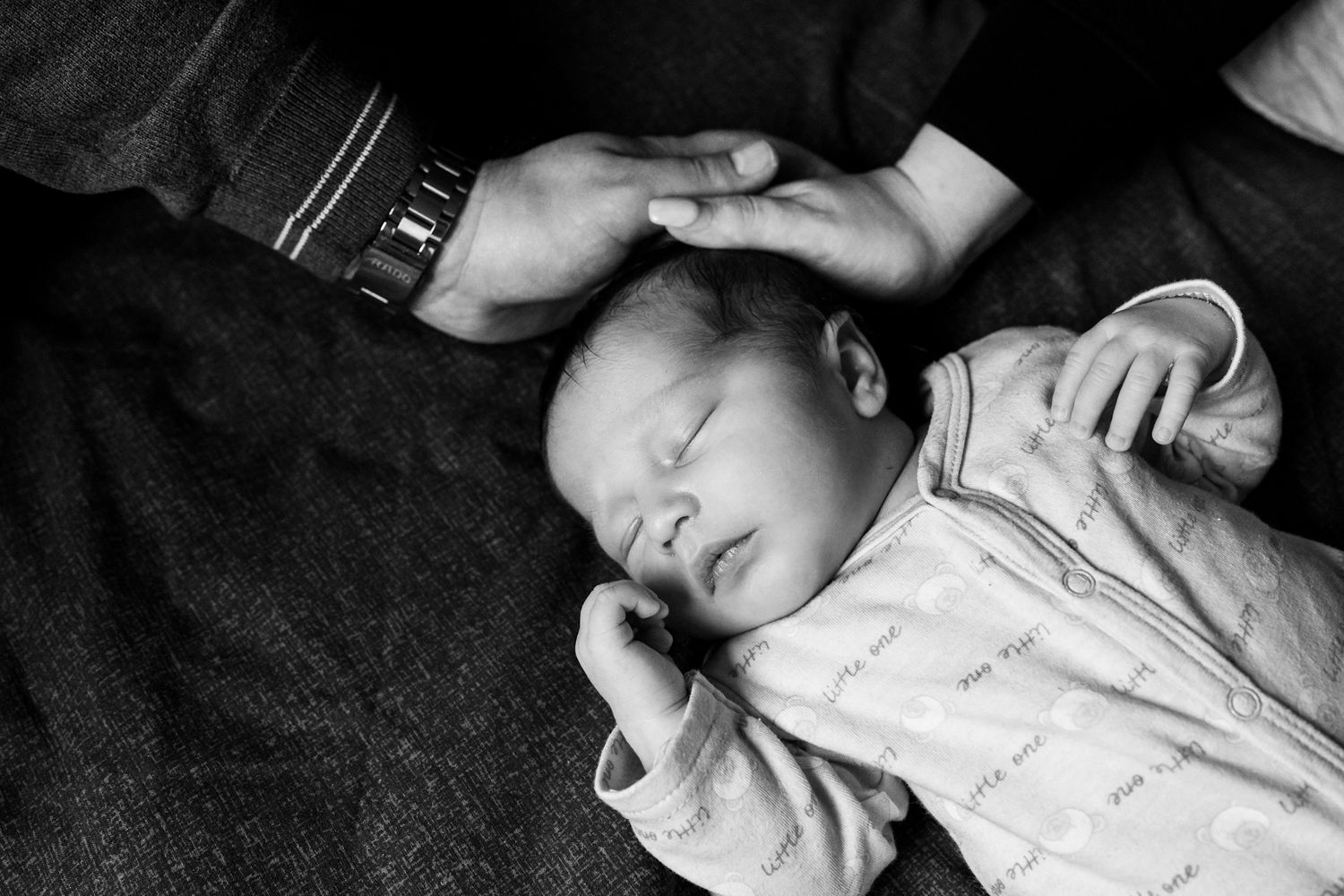 Newborn-photography-at-home-parents-hands-touch-their-sons-head