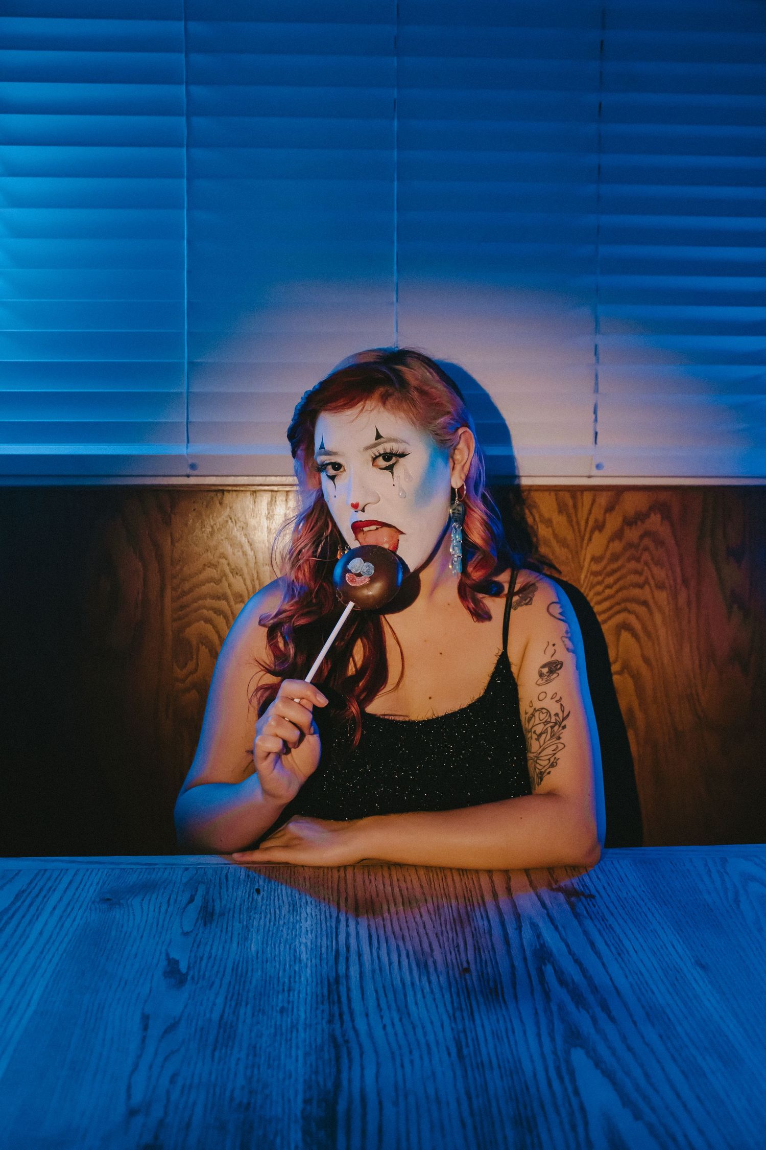 A moody portrait with blue lighting of someone singing into a microphone.