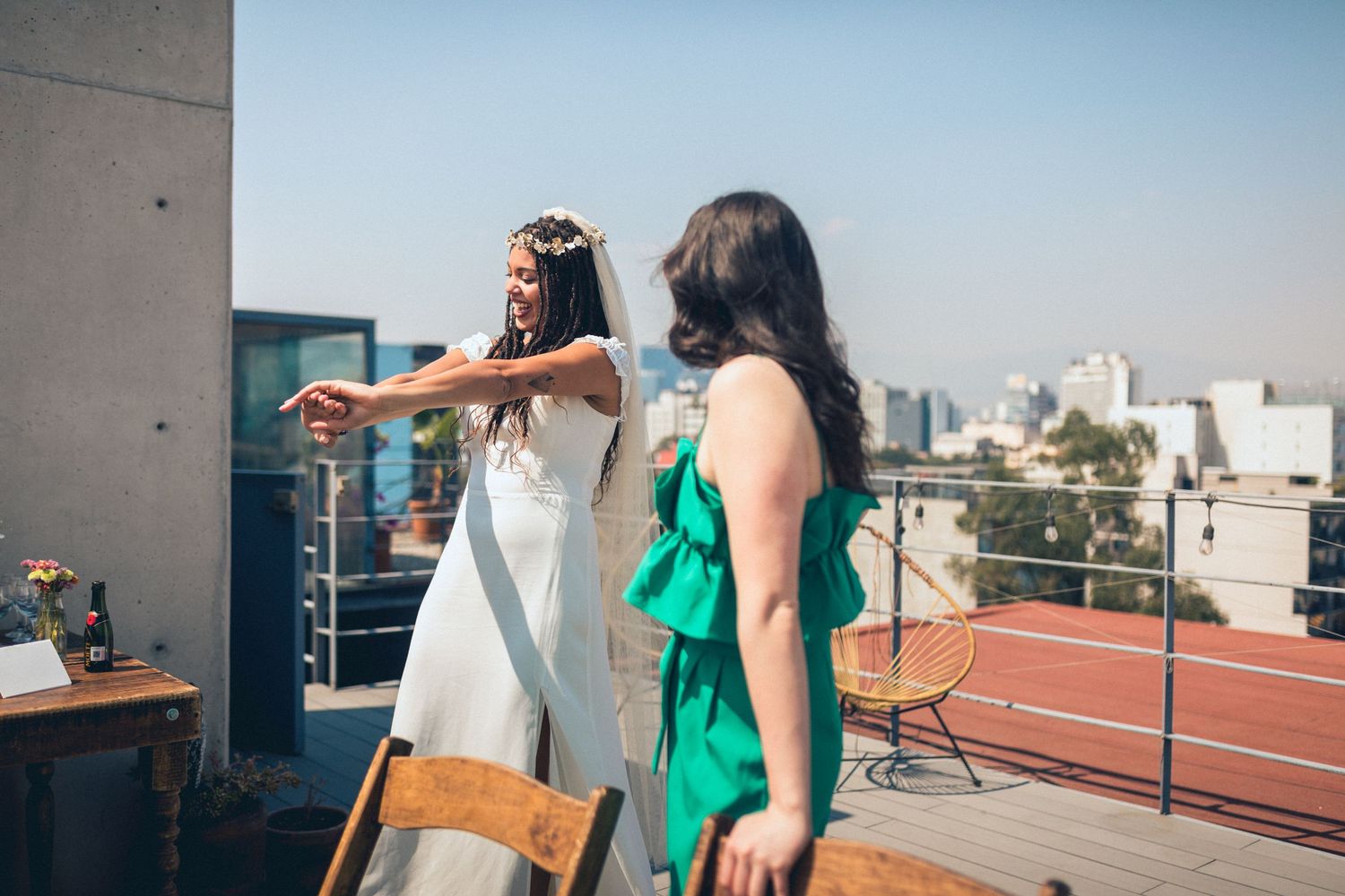Wedding celebration on modern urban rooftop with concrete walls and city views.