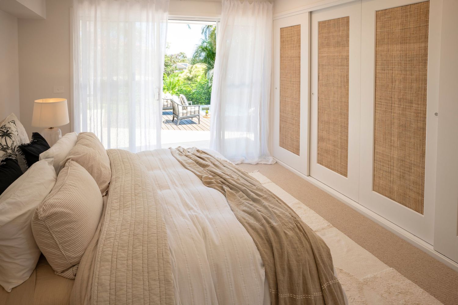 Main bedroom overlooking spa area with rattan wardrobe doors