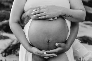 Close-up shots of hands cradling a pregnant belly with a small anchor tattoo visible.