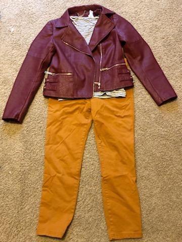 Burgundy leather jacket and mustard pants outfit laid flat on carpet.