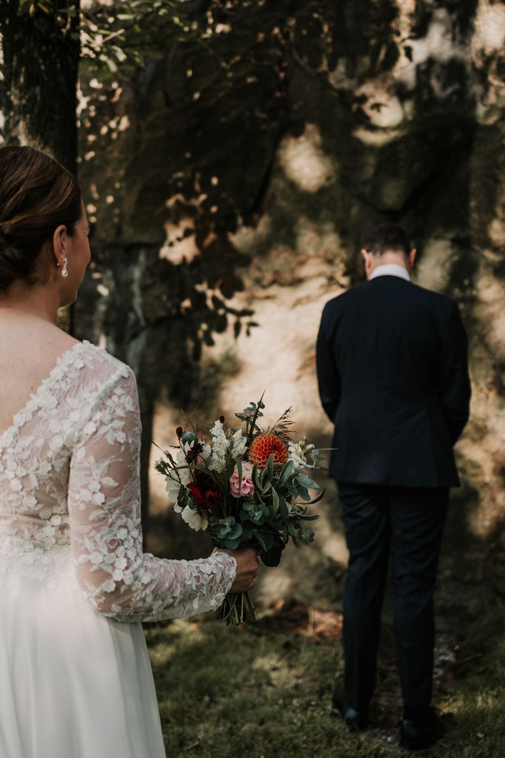 First look. Brudgum står och väntar på brud. Brud har en vacker egengjord blomsterbukett