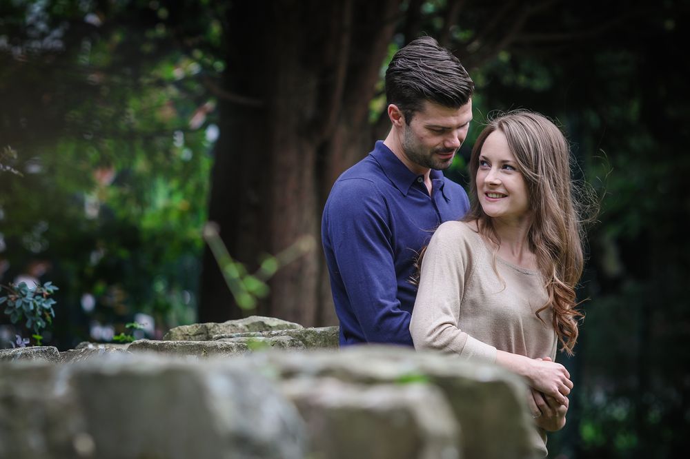 Happy smiling couple hug during a resting moment in their local Manchester park