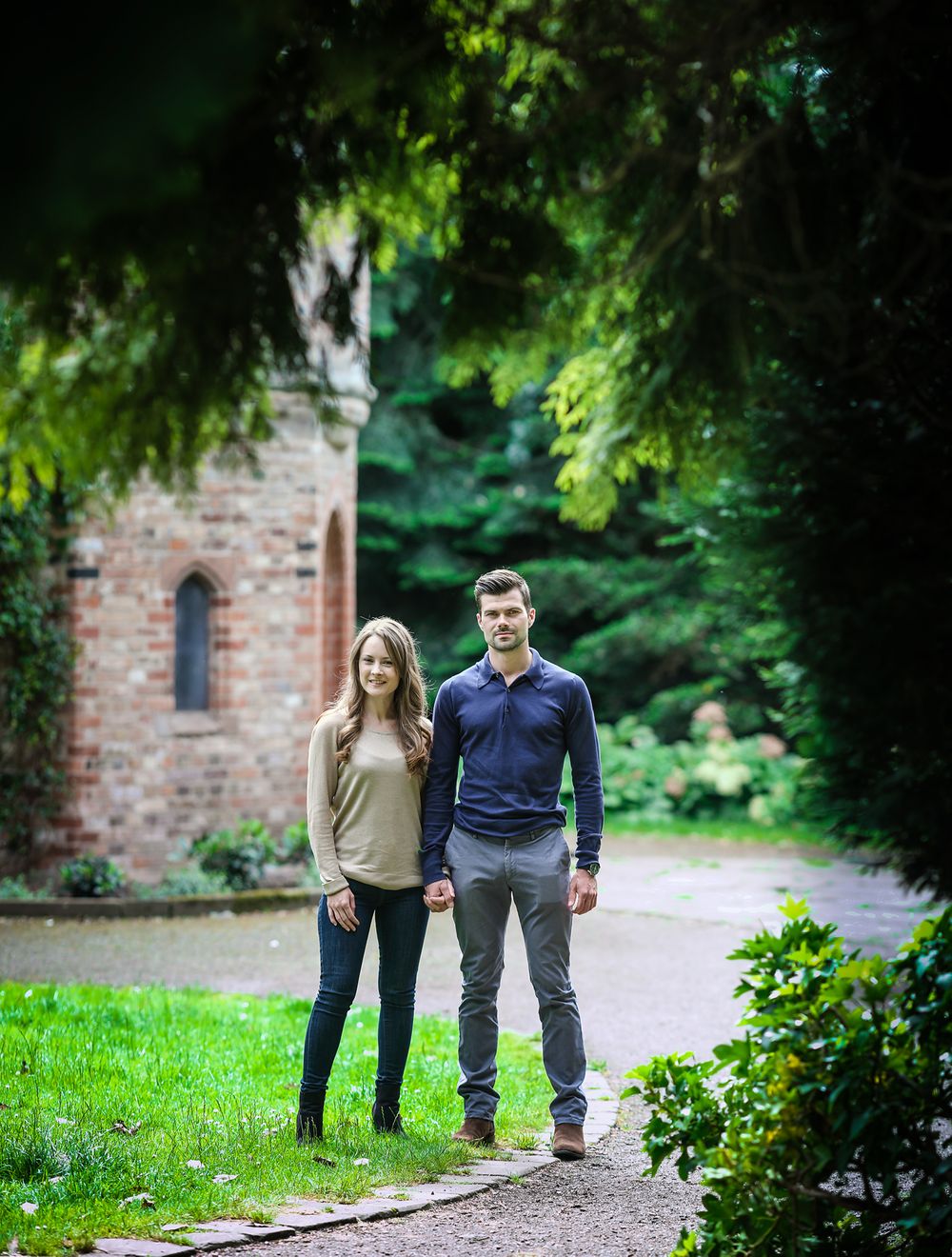 Mna and woman stand together framed by green foliage next the the Dovecoat building in Walkden Gardens Sale Manchester