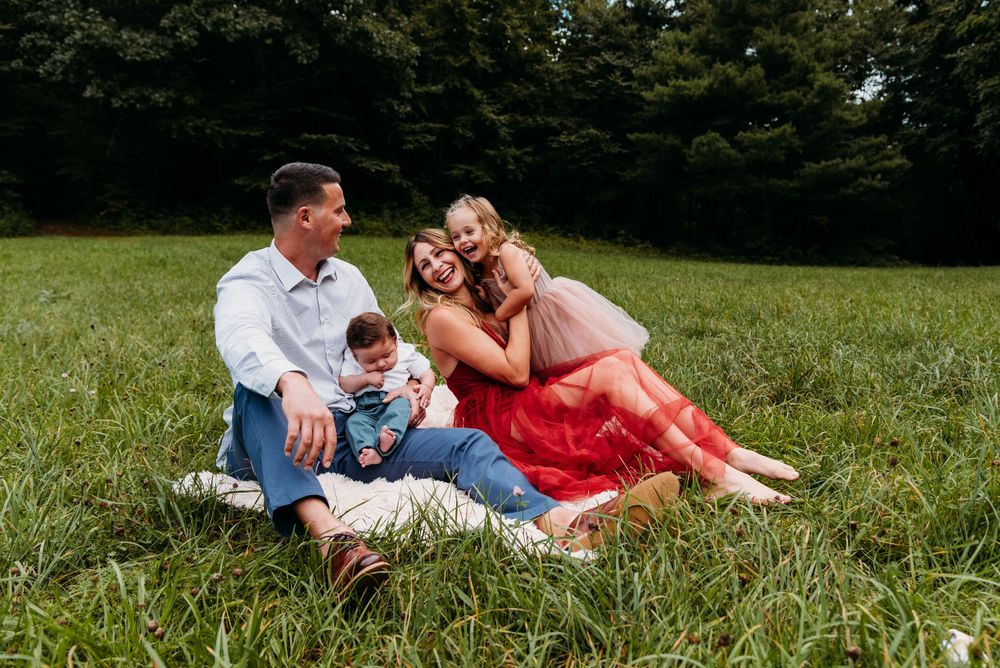 Family enjoying a picnic together on a grassy field on a sunny day.