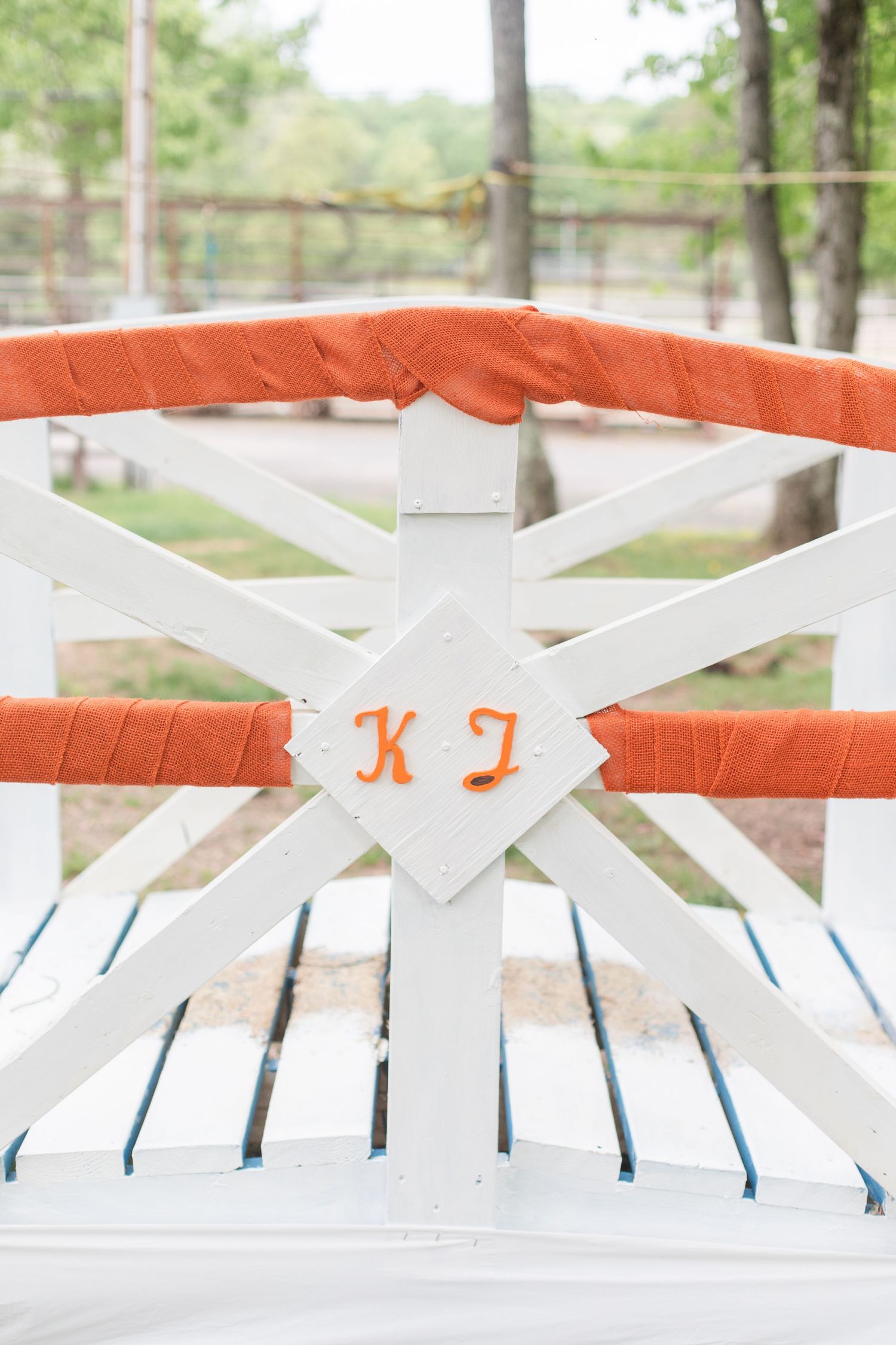 White wooden fence sections with coral accents at outdoor venue.