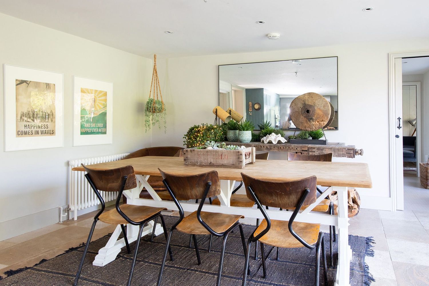 Dining room with live edge wooden table, modern chairs and hanging plants.