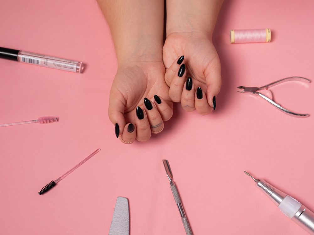 Flat lay of beauty and cosmetic products arranged on pink background.