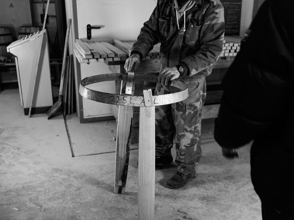 Black and white image of craftsman working on ski equipment in workshop.