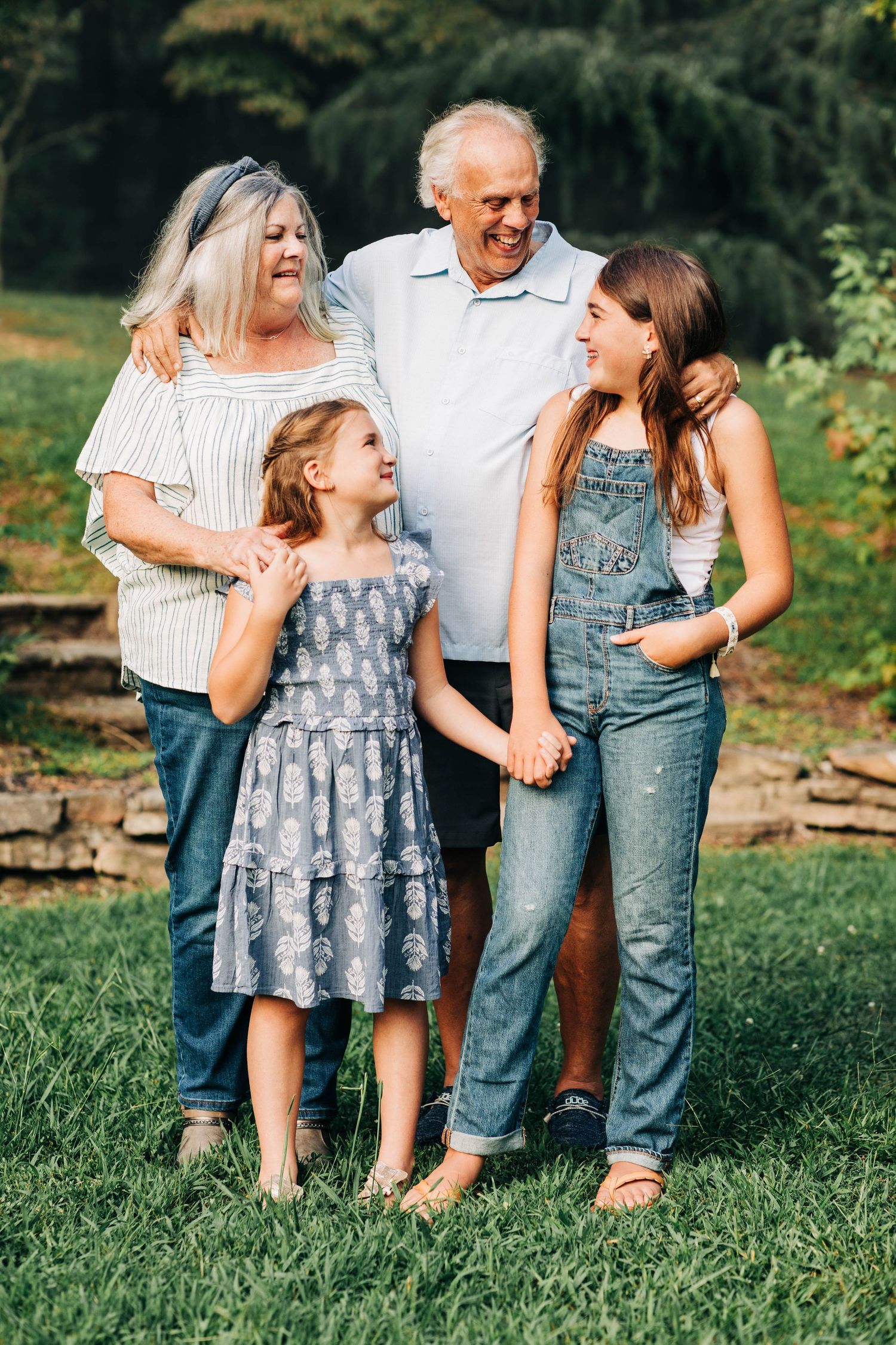 A multigenerational group poses together outdoors in casual clothing.