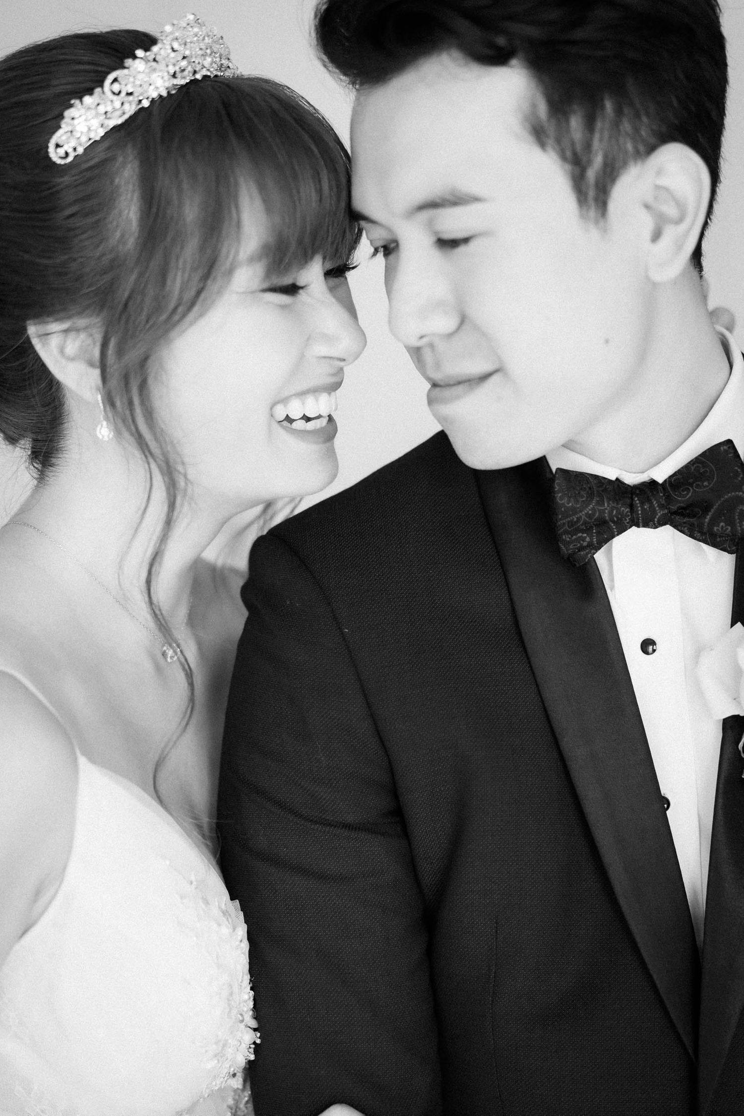 A black and white close-up wedding portrait capturing an intimate moment between newlyweds.