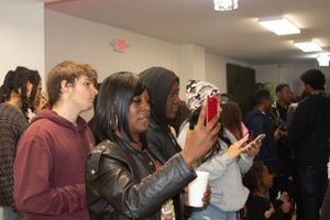 People using phones to take photos at an indoor event.