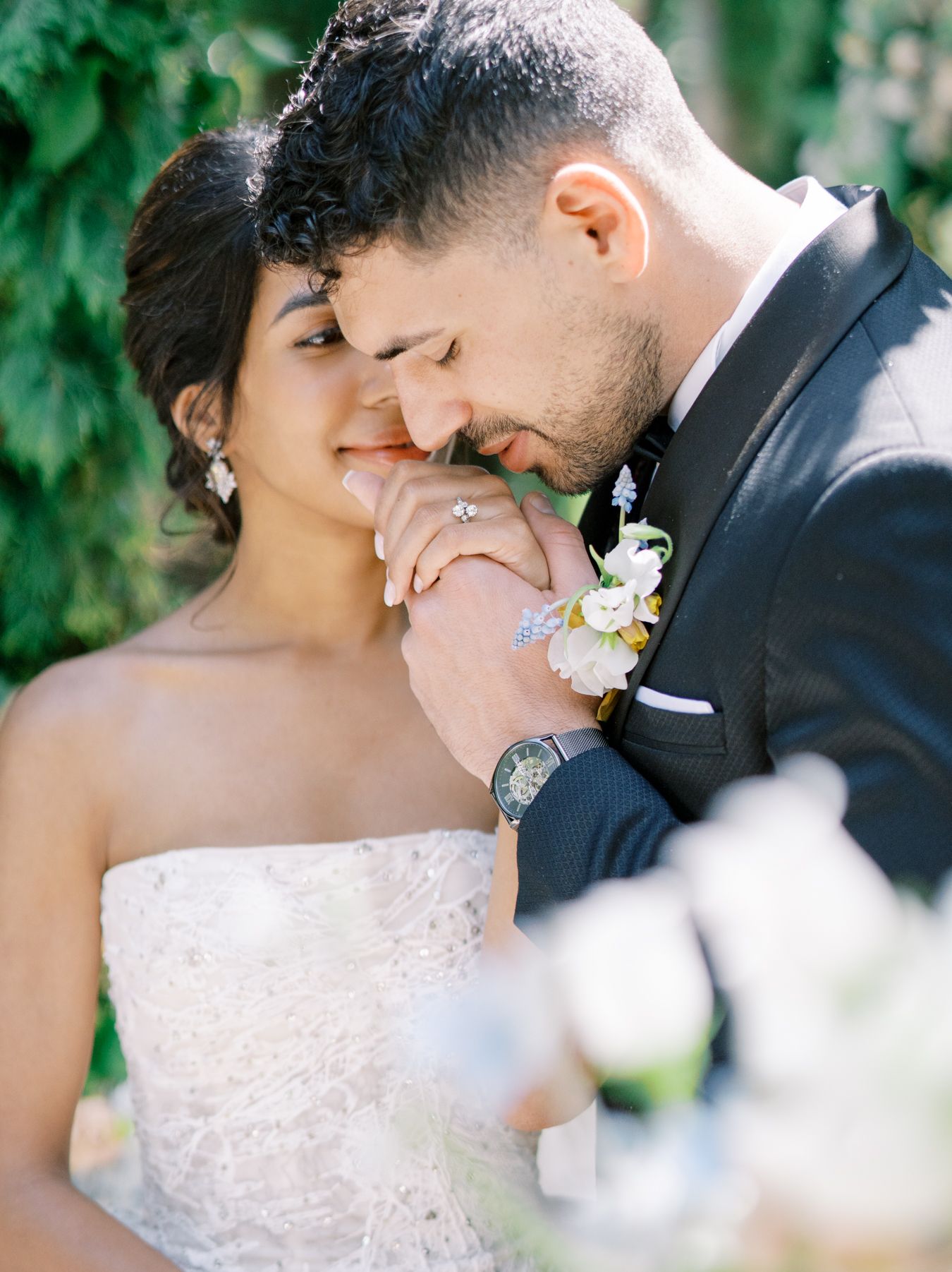 Intimate wedding moment captured in a blooming garden setting.